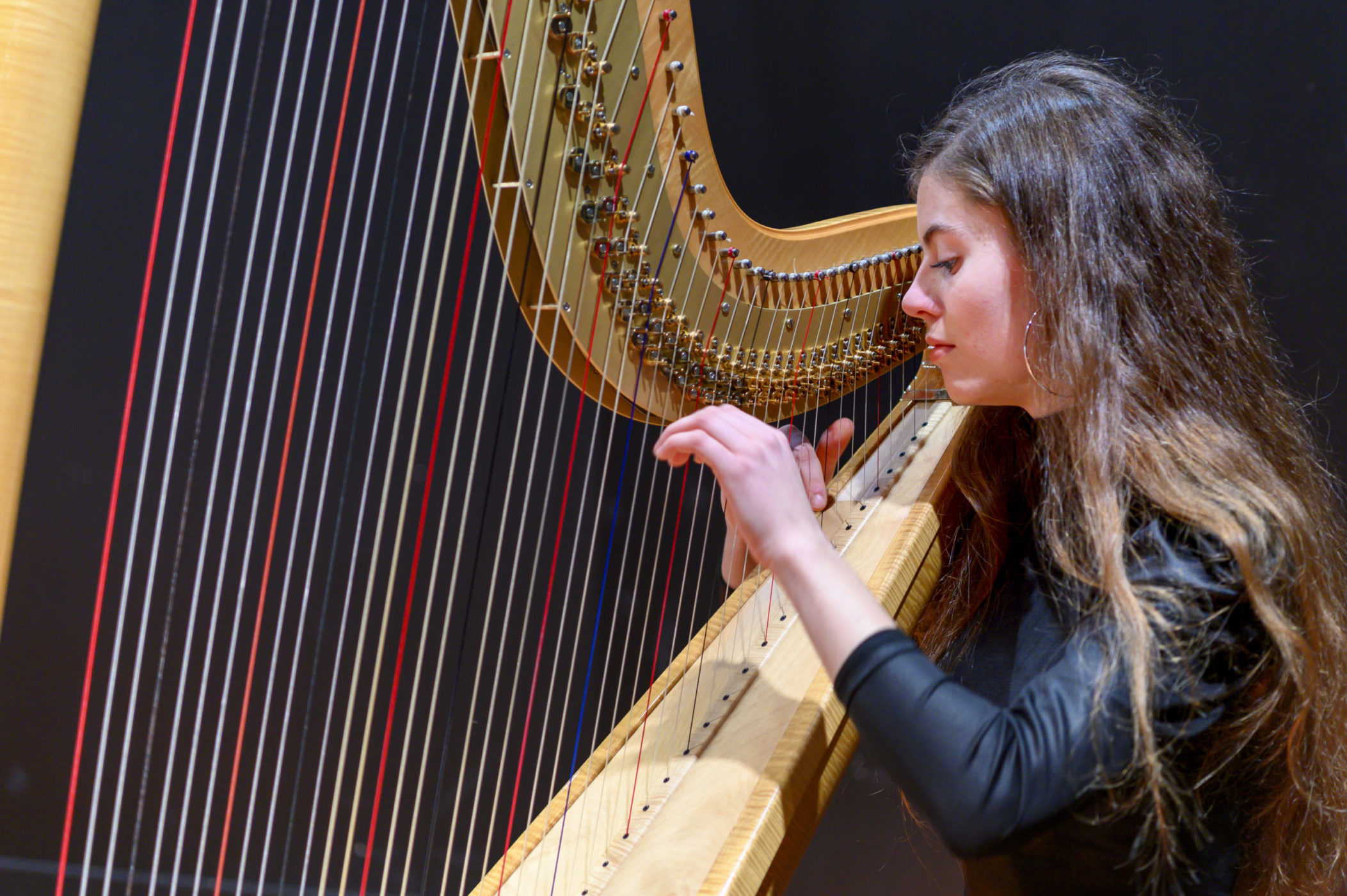 une élève joue de la harpe dans une masterclass de musique