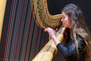 une élève du conservatoire populaire s'entraine à jouer de la harpe
