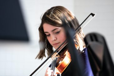 élève qui joue du violon, grâce au soutien des donateurs au conservatoire populaire