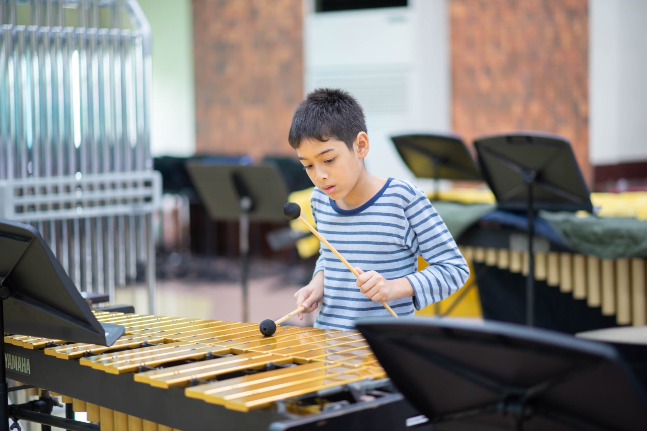 un enfant joue de la percussion en cours d'initiation